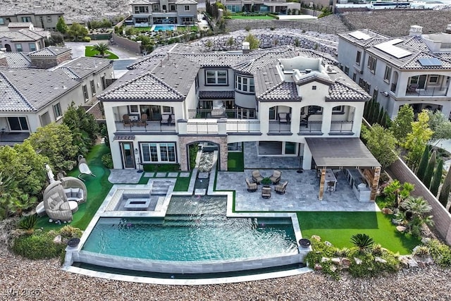 10 Olympia Outlook Dr, Las Vegas, NV 89141 - back of property with a balcony, an outdoor pool, a hot tub, a patio, and an outdoor hangout area