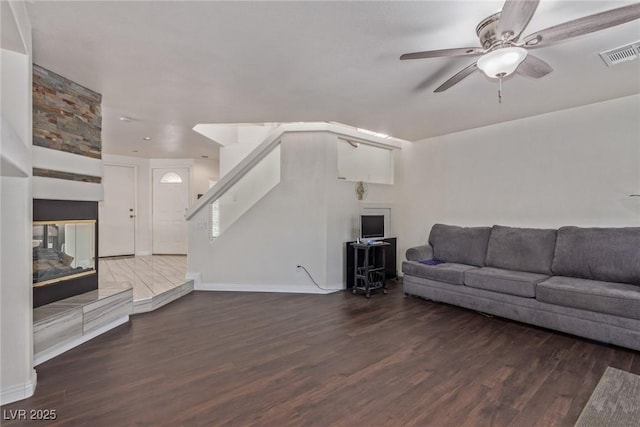 10103 Flagstaff Butte Ave, Las Vegas, NV 89148 - living area featuring baseboards, stairs, visible vents, ceiling fan, and wood finished floors
