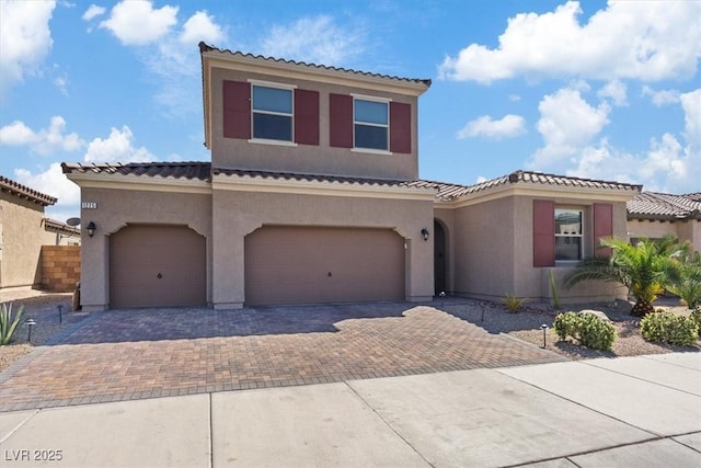 1225 Olivia Pkwy, Henderson, NV 89011 - mediterranean / spanish house with an attached garage, stucco siding, a tile roof, and decorative driveway