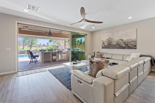 1225 Olivia Pkwy, Henderson, NV 89011 - living room with visible vents, a wealth of natural light, a ceiling fan, and wood finished floors
