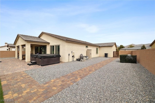 5455 Eleganza Ave, Pahrump, NV 89061 - rear view of property with a patio area, stucco siding, a hot tub, and a fenced backyard