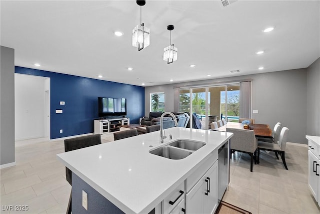5455 Eleganza Ave, Pahrump, NV 89061 - kitchen featuring stainless steel dishwasher, a sink, light countertops, hanging light fixtures, and open floor plan