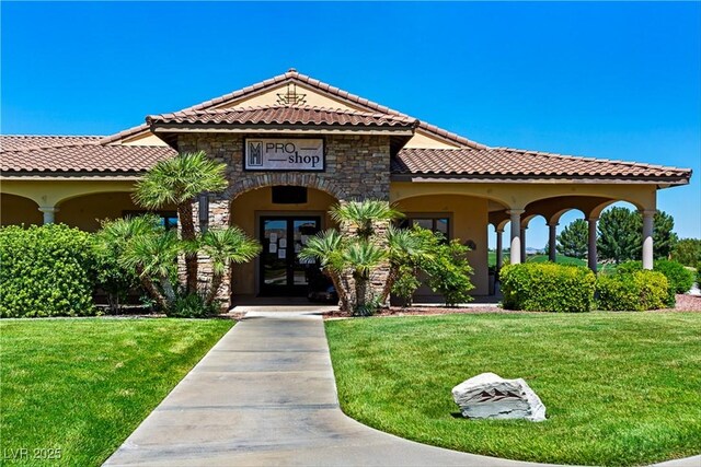 5455 Eleganza Ave, Pahrump, NV 89061 - mediterranean / spanish house with stucco siding, french doors, stone siding, a front lawn, and a tiled roof