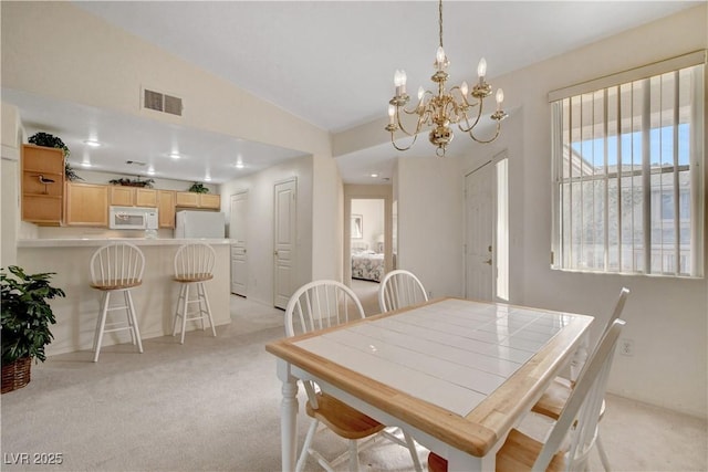 dining area with visible vents, an inviting chandelier, light colored carpet, and vaulted ceiling