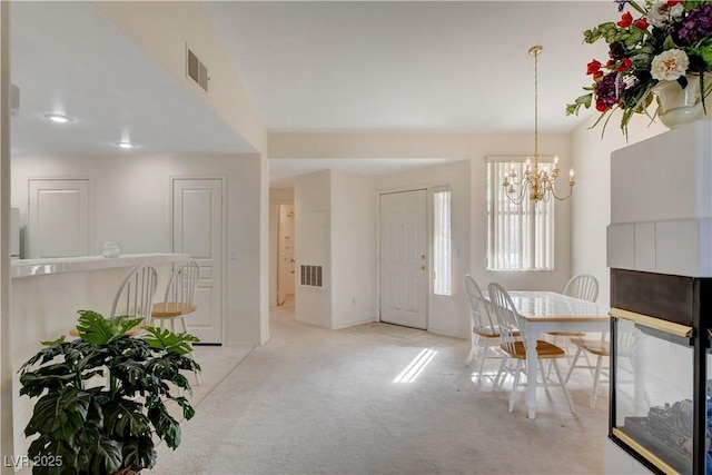 foyer with visible vents, carpet flooring, and a chandelier