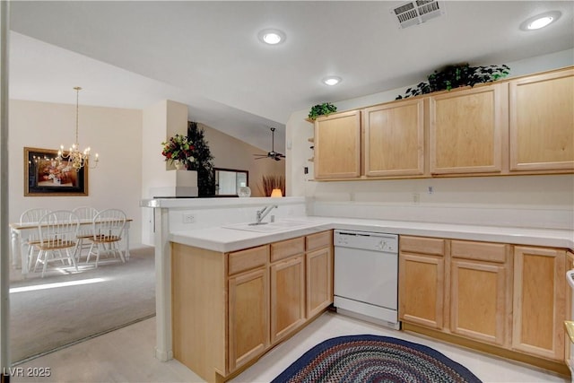 kitchen featuring light brown cabinets, dishwasher, a sink, and visible vents