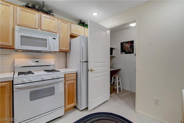 kitchen featuring white appliances and light brown cabinets