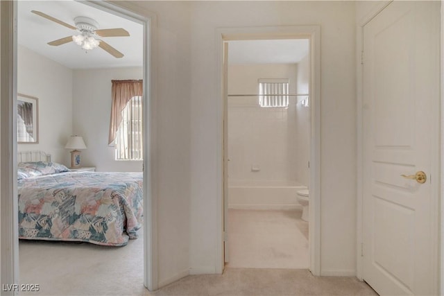 carpeted bedroom featuring ensuite bathroom and baseboards