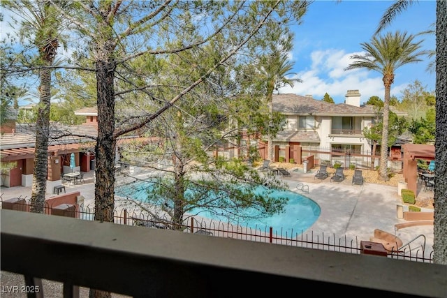 community pool with fence and a patio