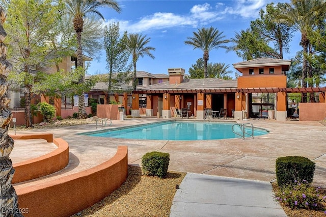 community pool with fence and a patio
