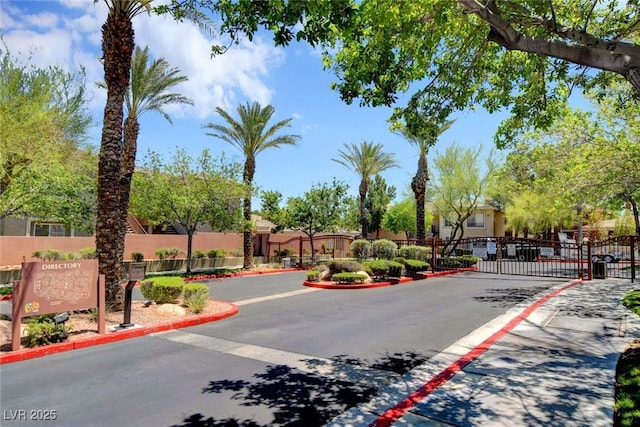 view of street with a gated entry, curbs, and a gate