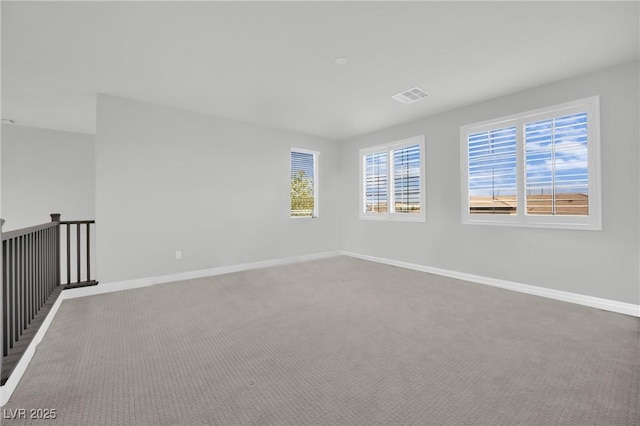 unfurnished room with baseboards, carpet, and visible vents