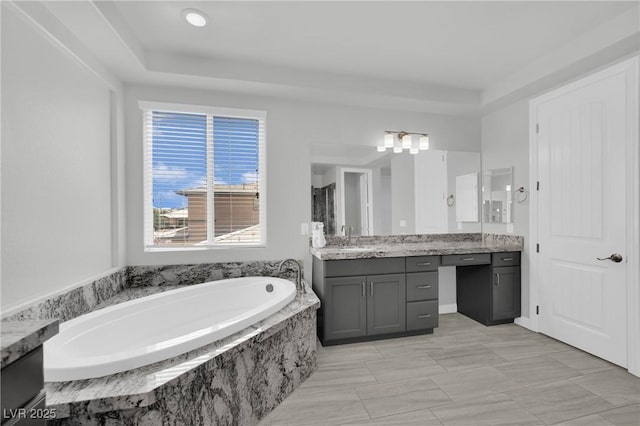 bathroom featuring walk in shower, vanity, and a garden tub