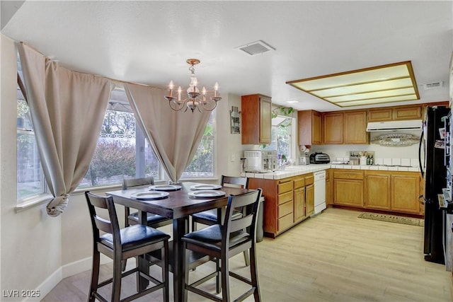 dining room featuring visible vents, baseboards, a notable chandelier, and light wood-style floors