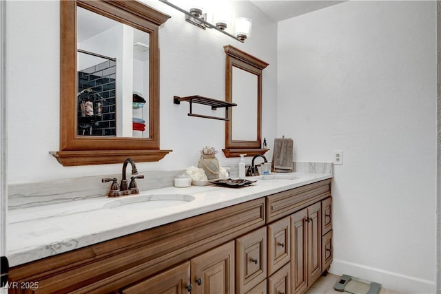 full bathroom with double vanity, baseboards, and a sink