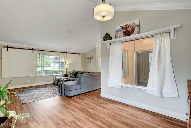 unfurnished living room featuring ornamental molding, baseboards, wood finished floors, and lofted ceiling