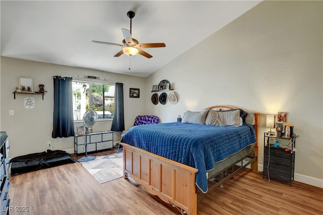 bedroom with light wood-style floors, baseboards, a ceiling fan, and lofted ceiling