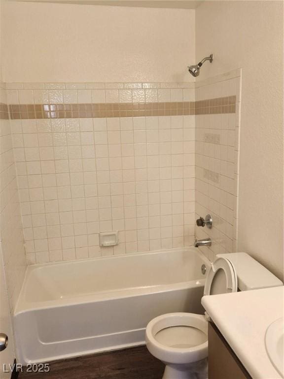 bathroom featuring toilet, washtub / shower combination, vanity, and wood finished floors