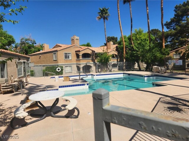 community pool featuring a patio area and fence