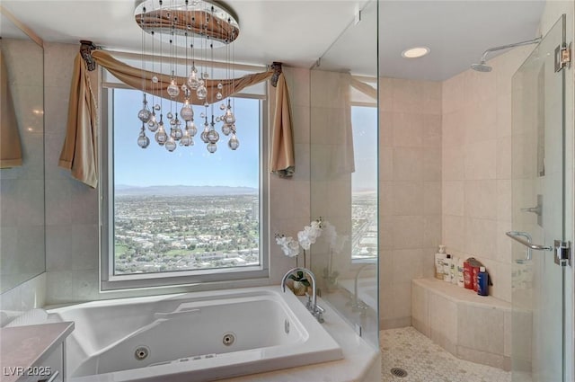 full bathroom featuring a shower stall, a tub with jets, and a healthy amount of sunlight