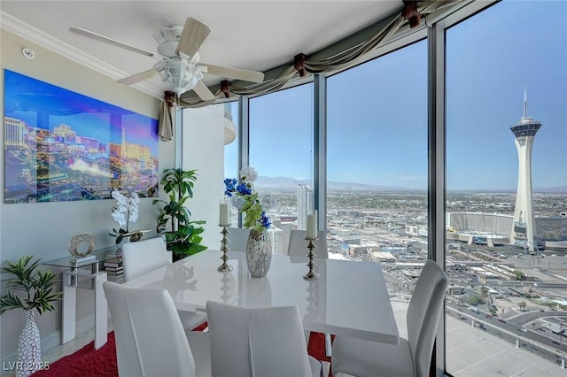 dining area featuring a city view, a ceiling fan, and ornamental molding