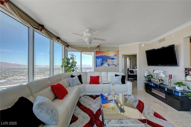 living area with ceiling fan and ornamental molding