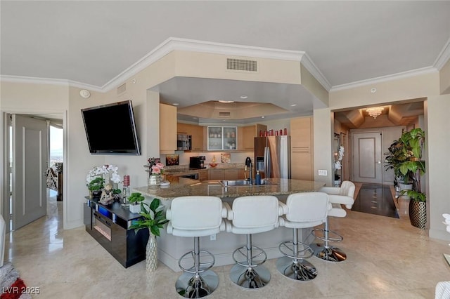 kitchen with ornamental molding, visible vents, a sink, a peninsula, and appliances with stainless steel finishes