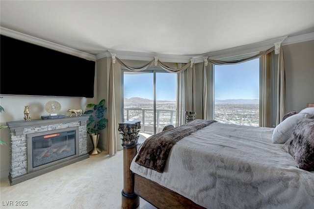 bedroom with a stone fireplace, crown molding, and a mountain view
