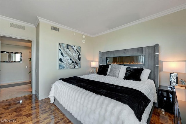 bedroom featuring baseboards, ornamental molding, visible vents, and wood finished floors