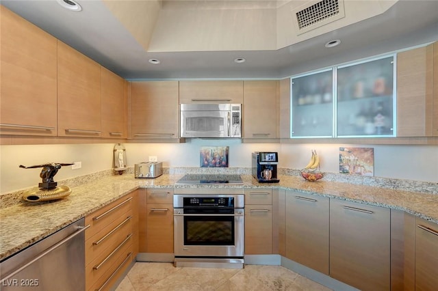 kitchen featuring stainless steel appliances, visible vents, recessed lighting, glass insert cabinets, and light stone countertops