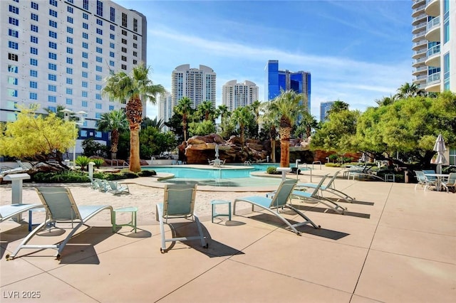community pool with a city view and a patio