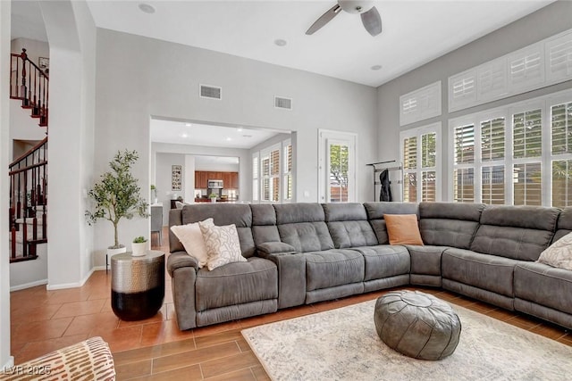 9413 Artesian Oak Ct, Las Vegas, NV 89149 - living room featuring stairway, a towering ceiling, visible vents, baseboards, and ceiling fan