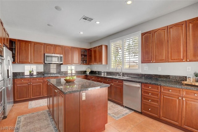 9413 Artesian Oak Ct, Las Vegas, NV 89149 - kitchen featuring stainless steel appliances, visible vents, a sink, a center island, and brown cabinetry