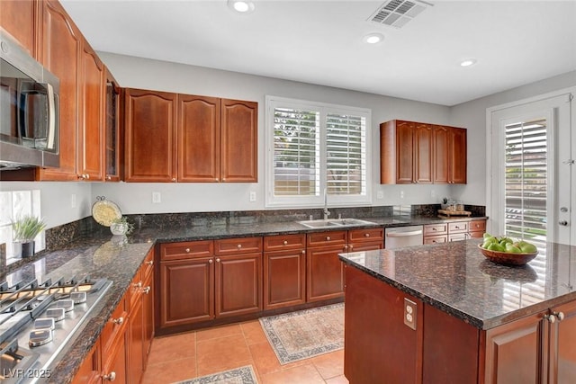 9413 Artesian Oak Ct, Las Vegas, NV 89149 - kitchen with appliances with stainless steel finishes, dark stone countertops, a sink, and visible vents