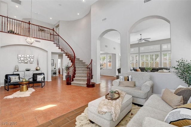 9413 Artesian Oak Ct, Las Vegas, NV 89149 - tiled living area with a high ceiling, visible vents, a ceiling fan, arched walkways, and stairs