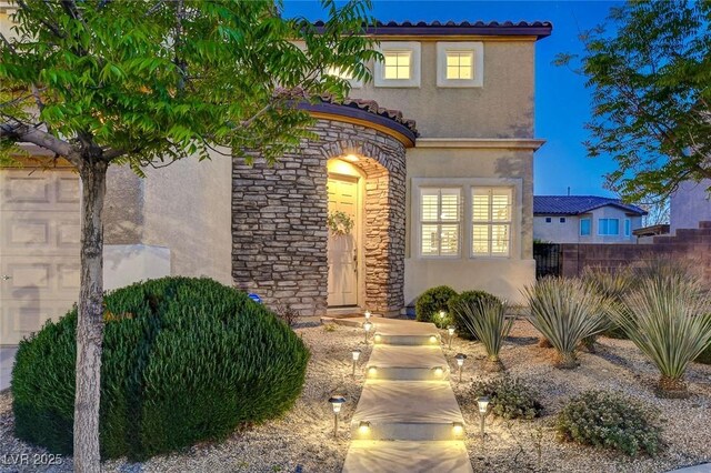 9413 Artesian Oak Ct, Las Vegas, NV 89149 - view of exterior entry with stone siding, a tiled roof, stucco siding, and fence