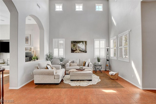 9413 Artesian Oak Ct, Las Vegas, NV 89149 - living room featuring plenty of natural light, a high ceiling, visible vents, and light tile patterned floors