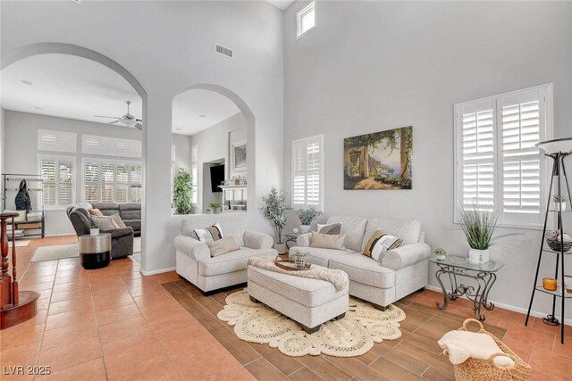9413 Artesian Oak Ct, Las Vegas, NV 89149 - living room featuring ceiling fan, arched walkways, baseboards, a high ceiling, and visible vents