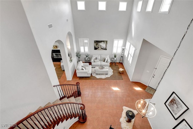9413 Artesian Oak Ct, Las Vegas, NV 89149 - living room featuring arched walkways, a high ceiling, tile patterned floors, and visible vents