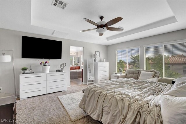 9413 Artesian Oak Ct, Las Vegas, NV 89149 - bedroom with light colored carpet, a tray ceiling, visible vents, and ensuite bathroom