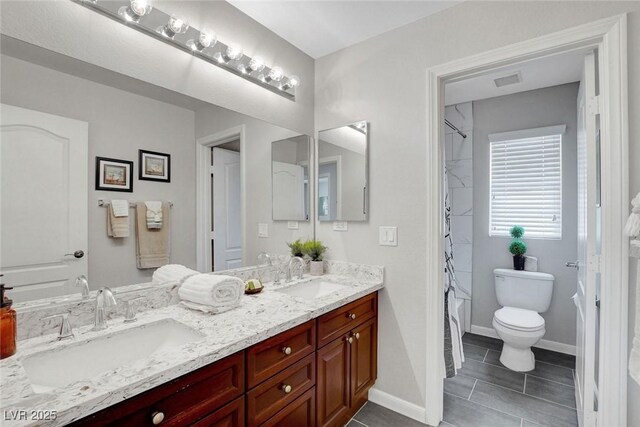 9413 Artesian Oak Ct, Las Vegas, NV 89149 - bathroom with double vanity, tile patterned floors, toilet, and a sink