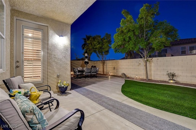 9413 Artesian Oak Ct, Las Vegas, NV 89149 - patio at night featuring an outdoor hangout area, outdoor dining area, and a fenced backyard
