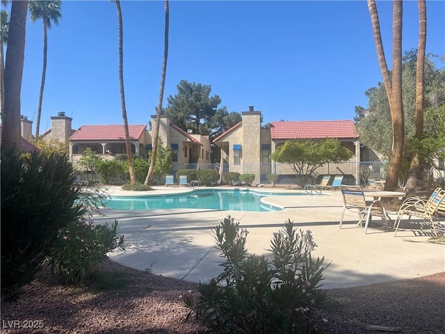 community pool featuring a patio area and fence