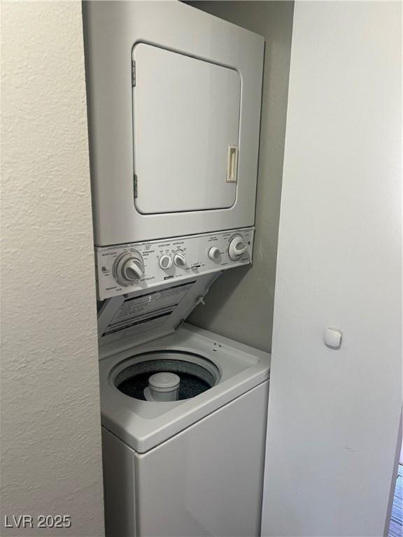 laundry room with stacked washer and dryer and laundry area