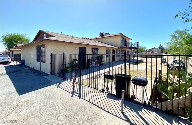 bungalow-style house featuring fence and stucco siding