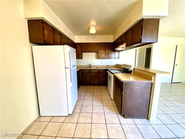 kitchen with electric stove, light countertops, freestanding refrigerator, and light tile patterned flooring