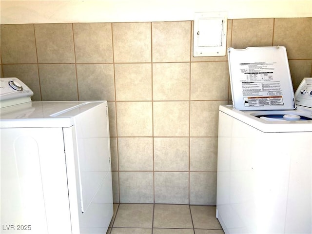 laundry room with light tile patterned floors, laundry area, washer / dryer, and electric panel