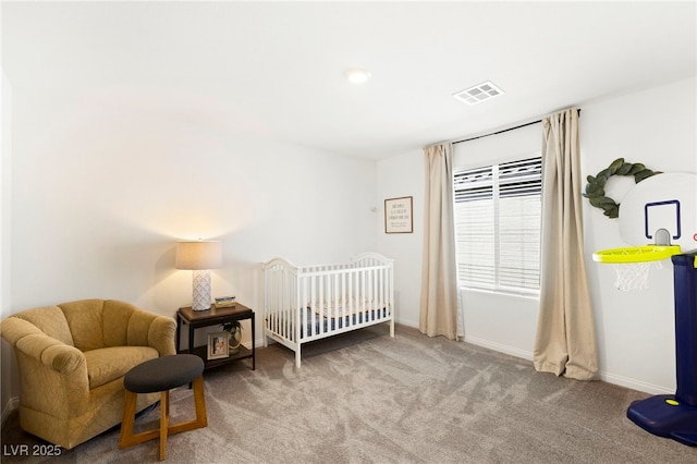 carpeted bedroom with baseboards and a nursery area
