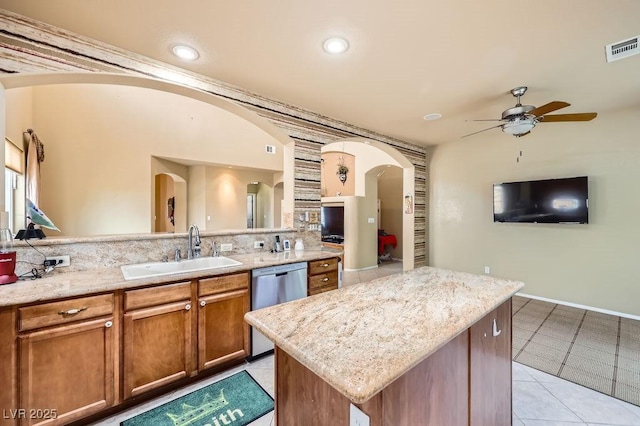 215 Sunset Shower Dr, Henderson, NV 89012 - kitchen featuring arched walkways, brown cabinetry, ceiling fan, dishwasher, and a sink