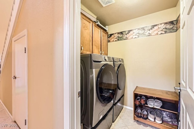 215 Sunset Shower Dr, Henderson, NV 89012 - laundry room with light tile patterned floors, visible vents, washer and clothes dryer, and cabinet space